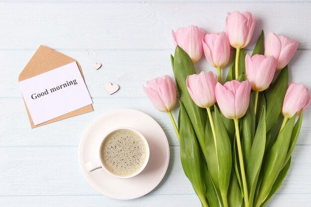 Een boeket van mooie tulpen en een kaart voor tekst op een houten achtergrond