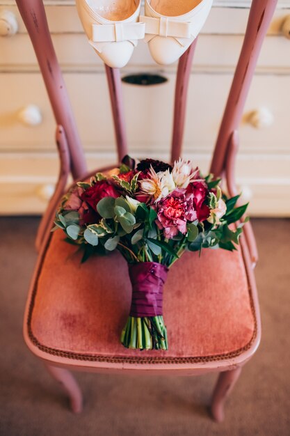 Een boeket van rode bloemen, zwarte bessen en groen.