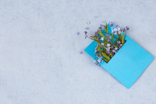 een boeket van vergeet-mij-nietjes in een blauwe envelop en vrije ruimte voor tekst
