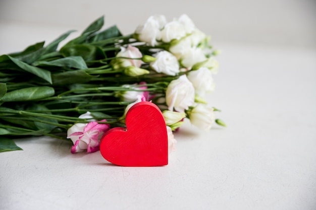 Een boeket van witte eustoma bloem met een hart op wit