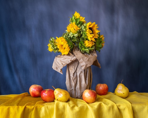 Een boeket zonnebloemen in kraanpapier. Appels en peren