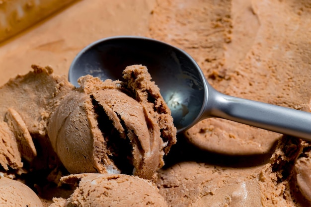 Een bolletje chocolade-ijs met een lepel op een bakplaat.