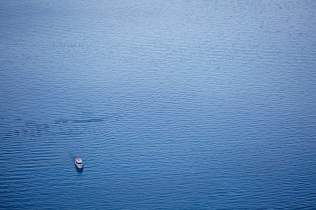 Een boot bevindt zich van bovenaf in het diepblauwe water