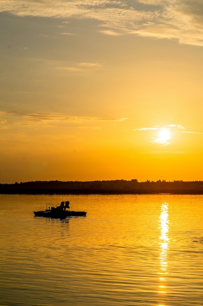 Foto een boot is in het water met de zon achter zich