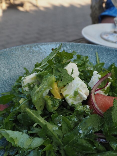 Een bord eten met een groene salade erop