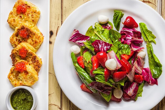 Een bord eten met een salade en een salade erop