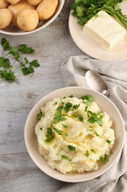 Een bord met aardappelpuree overgoten met gesmolten boter en gekruid met greens