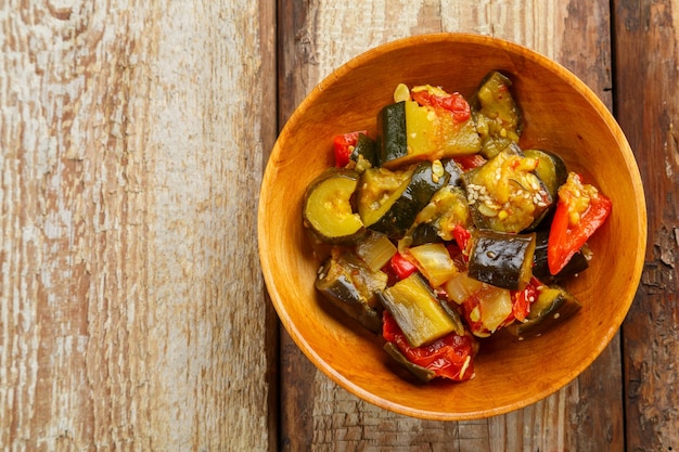 Een bord met gegrilde groenten op een houten tafelkopieruimte