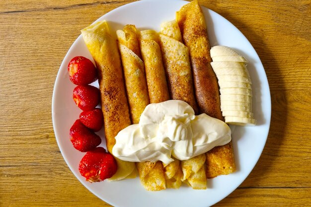 Een bord met heerlijke pannenkoeken fruit en slagroom Heerlijk ontbijt