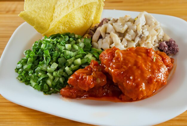 Een bord met kip en groenten.