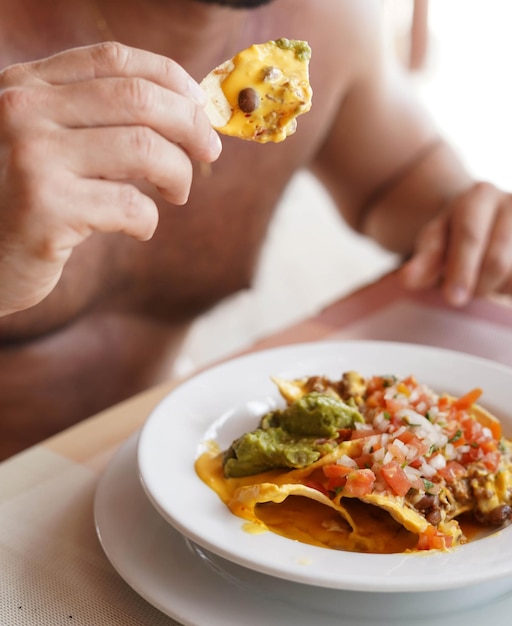 Een bord nacho's met kaasvlees en guacamole