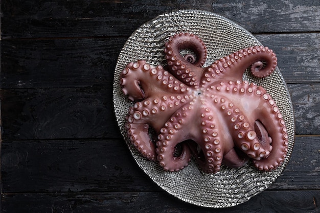 Een bord octopus op een donkere houten tafel