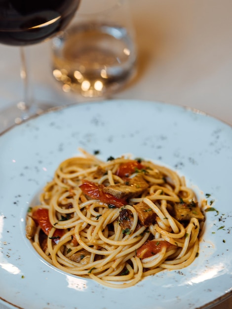 Foto een bord pasta met een vork en een glas wijn.