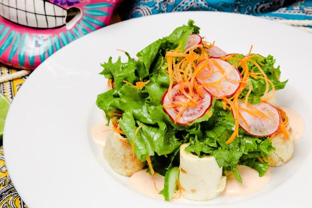 Een bord salade met worteltjes en sla