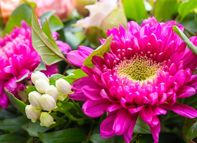 Een bos bloemen waarvan er één een roze bloem in het midden heeft.