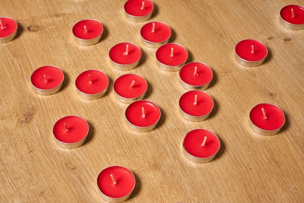 Een bos rode kaarsen op een houten oppervlak