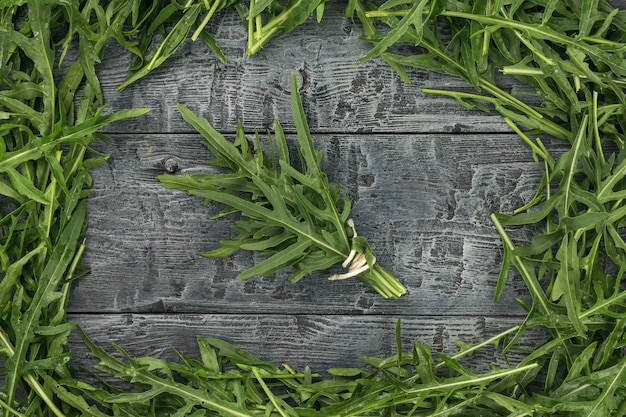 Een bos rucola in een frame van groen op een houten tafel Plat gelegd