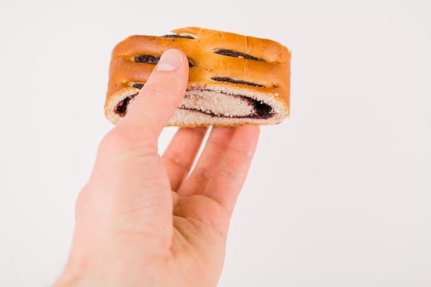 Een boterbroodje met maanzaad op een wit bord in de hand van een man