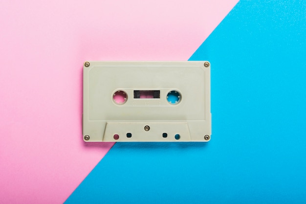 Een bovenaanzicht van cassette tape op dubbele roze en blauwe achtergrond