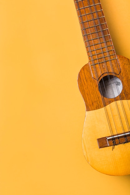 Foto een bovenaanzicht van de ukelele op gele achtergrond