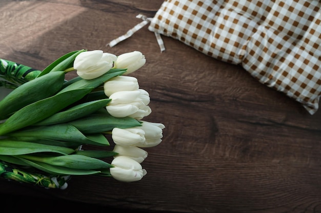 Een bovenaanzicht van een boeket prachtige witte tulpen in een witte decoratieve rieten mand