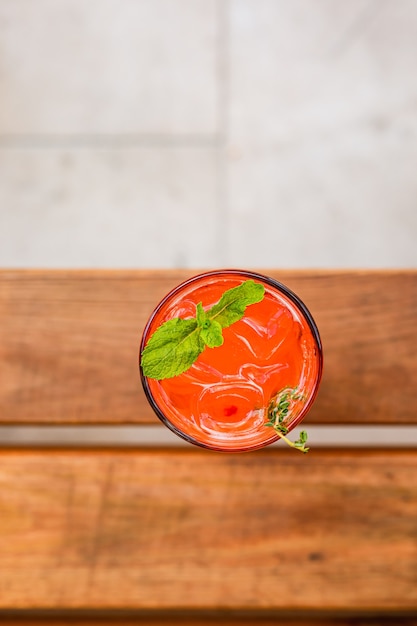 Foto een bovenaanzicht van een verfrissende frambozen- en passievruchtlimonade in een longdrinkglas gegarneerd met een munttakje en tijm