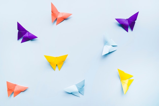 Een bovenaanzicht van kleurrijke origami papier vlinders op blauwe achtergrond