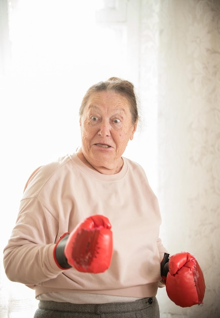 Een boze oude vrouw in bokshandschoenen