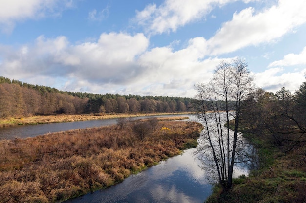 Een brede rivier in het herfstseizoen