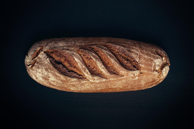 Een brood van roggebrood op een zwarte achtergrond.