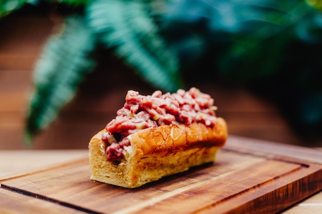 Een broodje gehakt met rood vlees erop