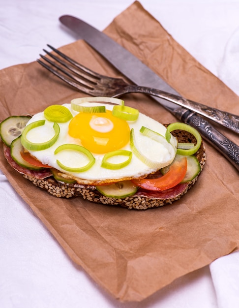 Een broodje met gebakken ei en een stukje roggebrood