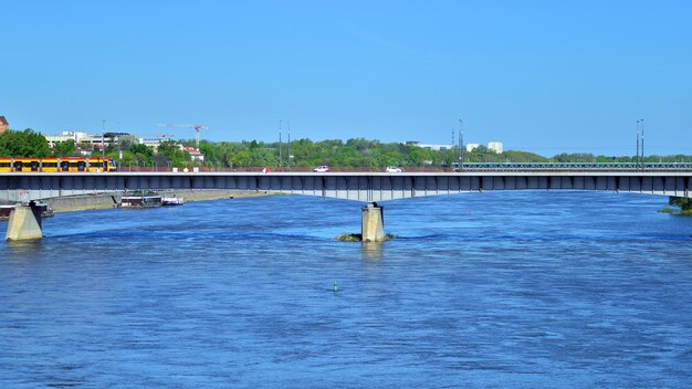 een brug over een rivier met een boot in het water