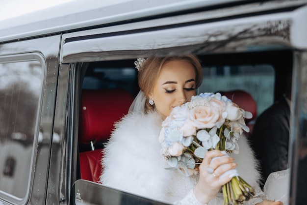 Foto een bruid houdt een boeket bloemen in een auto.