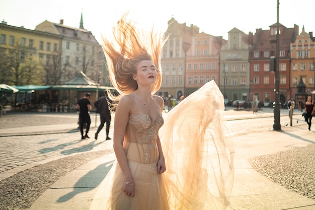 Een bruid in een trouwjurk met lang haar in het oude centrum van Wroclaw. Bruiloft fotoshoot in het centrum van een oude stad in Poland.Wroclaw, Polen.