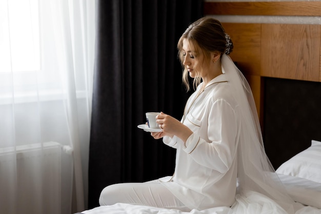 Een bruid zit op een bed in een hotelkamer