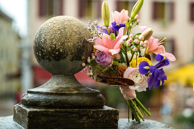 Foto een bruidsboeket met lelies staat bij regenachtig weer op straat.wedding decor.