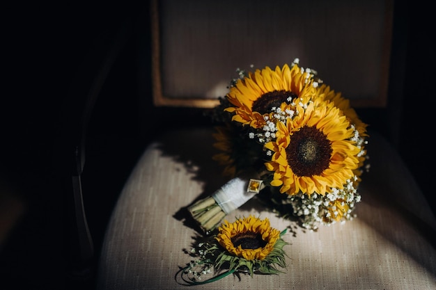 Een bruidsboeket met zonnebloemen ligt op een antieke stoel wedding decor