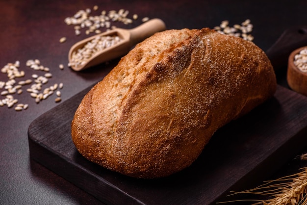 Een bruin brood met graankorrels op een houten snijplank