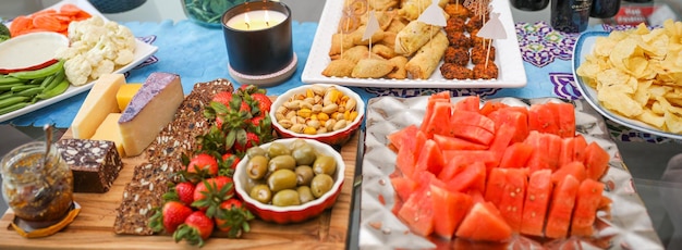 Een buffettafel met een verscheidenheid aan gerechten, waaronder fruit en groenten.