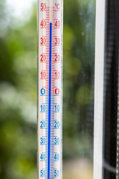 Foto een celsius-thermometer op een raamkozijn toont hoge temperaturen van 43 graden tijdens een abnormale hitte buiten