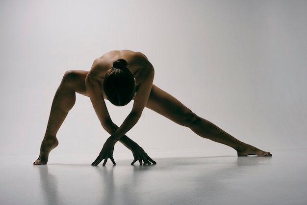 een charmant meisje demonstreert stretching en yoga-asana's in een fotostudio