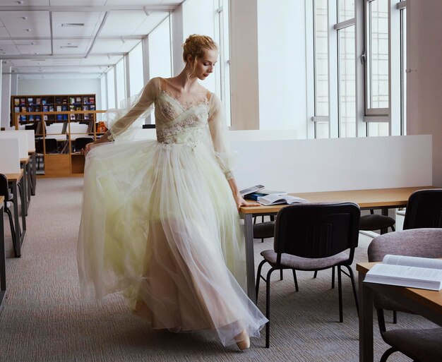 Foto een charmante ballerina ging naar de bibliotheek om een nieuw boek te kiezen tijdens een pauze die je stretching en flexibiliteit toont