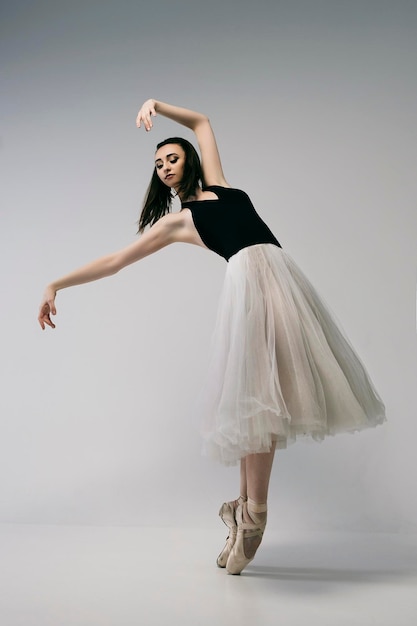 een charmante ballerina improviseert in een fotostudio en spat emoties eruit