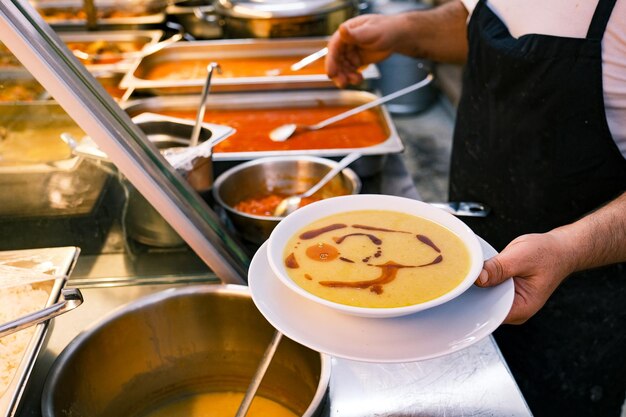 Foto een chef-kok met een bord linzensoep. turks traditioneel restaurant.