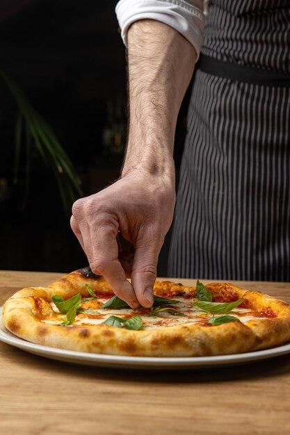 Een chef-kok snijdt een pizza op een bord