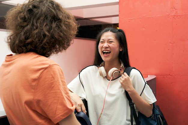 Een Chinese student praat en lacht met een klasgenoot op school