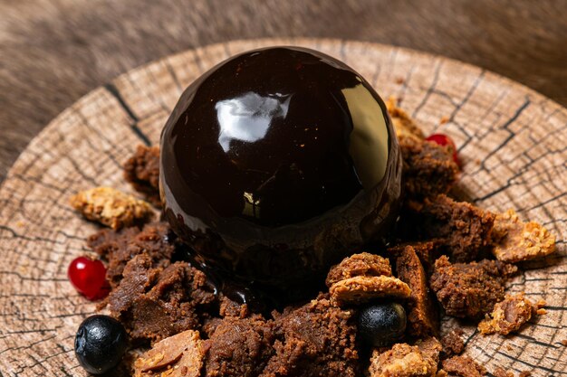 een chocolade bedekt met chocolade en kersen op een houten oppervlak