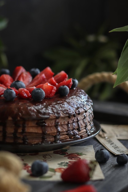 Een chocoladetaart met aardbeien en bosbessen erop