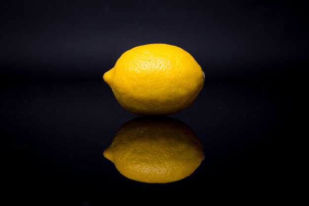 Foto eén citroen op een zwarte achtergrond.